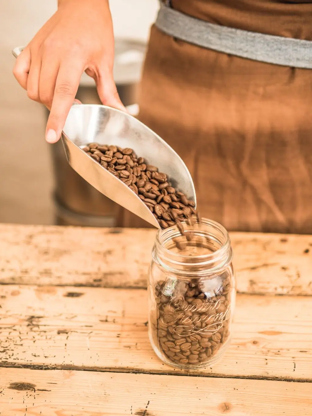 Frische Kaffeebohnen werden mit einer Schaufel in ein Vorratsglas gefüllt, Spezialitätenkaffee von La Molienda.